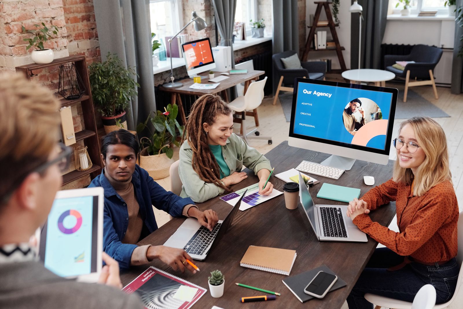 Creative team meeting around a laptop